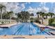Outdoor swimming pool with marked lanes surrounded by lounge chairs and tropical landscaping at 8639 Lower Villagewalk Cir, Orlando, FL 32827
