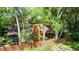 Aerial view of a wooded home featuring a brown roof, fence, and greenery at 1 W Village Dr, Oviedo, FL 32765
