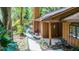 A cozy home features a tranquil walkway surrounded by mature landscaping and a covered entryway at 1 W Village Dr, Oviedo, FL 32765
