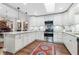 Bright kitchen featuring white cabinetry, stainless steel appliances, and granite countertops at 1 W Village Dr, Oviedo, FL 32765