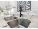 Stainless steel sink with black faucet and marble countertops under white cabinets at 1 W Village Dr, Oviedo, FL 32765