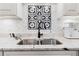 Close up on granite countertop with stainless steel sink, black faucet, and mosaic backsplash at 1 W Village Dr, Oviedo, FL 32765