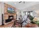 Cozy living room with a brick fireplace and mantle, plush seating, and lots of natural light at 1 W Village Dr, Oviedo, FL 32765