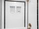 Modern shower with white tile, black accents, and built-in shelving at 1 W Village Dr, Oviedo, FL 32765