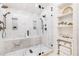 Spacious glass shower with marble walls and a built-in shelf, plus a shelving unit at 1 W Village Dr, Oviedo, FL 32765