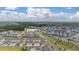 Stunning aerial view of townhomes, apartments, and a lake in a beautiful community on a partially cloudy day at 10684 Words Dr, Winter Garden, FL 34787