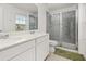 Bathroom featuring double sinks with quartz countertops and a tiled walk-in shower with glass door at 10684 Words Dr, Winter Garden, FL 34787