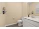 Half bathroom features a white vanity with sink, toilet, and a framed mirror at 10684 Words Dr, Winter Garden, FL 34787