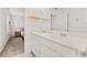 Bathroom featuring double sinks with quartz countertops, light wood shelves, and a view to bedroom at 10684 Words Dr, Winter Garden, FL 34787