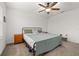 Bedroom featuring neutral carpet, a ceiling fan, and a metal bed frame with wooden nightstands at 10684 Words Dr, Winter Garden, FL 34787