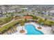 Aerial view of the community pool and playground with lounge chairs and palm trees at 10684 Words Dr, Winter Garden, FL 34787