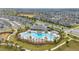 Fantastic aerial view of a neighborhood pool surrounded by palm trees, seating, and green space at 10684 Words Dr, Winter Garden, FL 34787