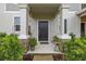 Close-up of the front door framed by columns, with a welcoming mat and decorative plants at 10684 Words Dr, Winter Garden, FL 34787