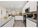 Beautiful kitchen with white cabinets, gray countertops, stainless steel appliances, and tile flooring at 10684 Words Dr, Winter Garden, FL 34787