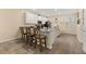 Bright kitchen with white cabinets, gray countertops, stainless steel appliances and seating at the breakfast bar at 10684 Words Dr, Winter Garden, FL 34787