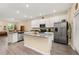 Open kitchen with white cabinets, gray countertops, stainless steel appliances, and a center island at 10684 Words Dr, Winter Garden, FL 34787