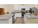 Modern kitchen features gray countertops, white cabinets, stainless steel appliances, and tile flooring at 10684 Words Dr, Winter Garden, FL 34787