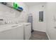 Functional laundry room equipped with a washer, dryer, and a water heater, plus ample shelving at 10684 Words Dr, Winter Garden, FL 34787