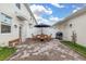 Paved outdoor patio with a wooden table and chairs, and an outdoor grill at 10684 Words Dr, Winter Garden, FL 34787