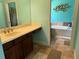 Well-lit bathroom featuring double vanity with decorative light fixture and tiled floors at 12238 Still Meadow Dr, Clermont, FL 34711
