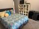Cozy bedroom featuring patterned bedding, storage shelf, and neutral wall colors at 12238 Still Meadow Dr, Clermont, FL 34711