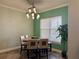 Dining room features wood floors and updated light fixture and view to exterior at 12238 Still Meadow Dr, Clermont, FL 34711
