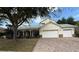 Charming exterior of home featuring a manicured lawn, brick driveway, and a two car garage at 12238 Still Meadow Dr, Clermont, FL 34711