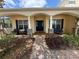 Inviting front porch with seating area, stone accents, brick pathway, and lush landscaping at 12238 Still Meadow Dr, Clermont, FL 34711