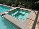 Close-up view of a luxurious in-ground hot tub with brick paver surround at 12238 Still Meadow Dr, Clermont, FL 34711