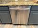Close up shot of the kitchen dishwasher with gray cabinets and granite countertops at 12238 Still Meadow Dr, Clermont, FL 34711