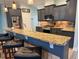 Modern kitchen featuring granite countertops, stainless appliances, dark gray cabinets, and pendant lighting at 12238 Still Meadow Dr, Clermont, FL 34711