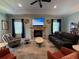 Living room featuring fireplace, TV, neutral tones, and lots of seating at 12238 Still Meadow Dr, Clermont, FL 34711