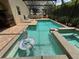 Large screened-in pool with an in-ground spa and lounge chairs nearby at 12238 Still Meadow Dr, Clermont, FL 34711