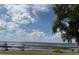 Picturesque view of a serene lake under a partly cloudy sky with vegetation along the shoreline at 12238 Still Meadow Dr, Clermont, FL 34711