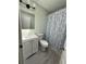 Bright bathroom features a vanity, toilet, and shower with a patterned curtain, offering functionality at 1528 Baltimore Dr, Orlando, FL 32810