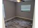 The gray bedroom features tiled floor, neutral walls, a window with blinds and a ceiling fan at 1528 Baltimore Dr, Orlando, FL 32810