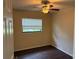 This cozy bedroom boasts hardwood floors, a ceiling fan and natural lighting from the exterior window at 1528 Baltimore Dr, Orlando, FL 32810