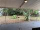 The covered patio overlooks a backyard with mature trees and ample space for outdoor living and entertaining at 1528 Baltimore Dr, Orlando, FL 32810