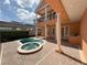 View of kidney shaped pool and spa with covered patio, upper balcony and outdoor kitchen with brick pavers at 1554 Corolla Ct, Reunion, FL 34747