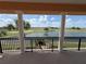 Balcony view overlooking a serene lake and golf course, framed by stately white columns at 1554 Corolla Ct, Reunion, FL 34747