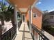 View of balcony with black metal railings and columns and a sidewalk leading to the home at 1554 Corolla Ct, Reunion, FL 34747