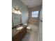 Bathroom featuring granite countertop, framed mirror, vanity lighting and tub and shower at 1554 Corolla Ct, Reunion, FL 34747