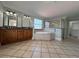 Spacious bathroom with tile flooring, tub, walk-in shower, double vanity with granite counter, and decorative wallpaper at 1554 Corolla Ct, Reunion, FL 34747