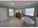 Elegant bathroom with a soaking tub, double vanity, decorative wallpaper, and tiled flooring at 1554 Corolla Ct, Reunion, FL 34747