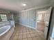 Bathroom featuring a bathtub, tiled flooring, and decorative wallpaper at 1554 Corolla Ct, Reunion, FL 34747