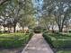 Picturesque community courtyard features manicured hedges, mature trees, and inviting walkways at 1554 Corolla Ct, Reunion, FL 34747