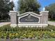 Community entrance sign with brick pillars and manicured flowerbeds at 1554 Corolla Ct, Reunion, FL 34747