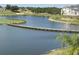 Scenic lake view with a wooden bridge, calm water, and green surroundings at 1554 Corolla Ct, Reunion, FL 34747