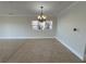 Large living area featuring tile flooring, a decorative chandelier, and large windows for natural light at 1554 Corolla Ct, Reunion, FL 34747
