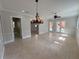 Spacious living room featuring tile flooring, an elegant chandelier, and views of the pool area at 1554 Corolla Ct, Reunion, FL 34747